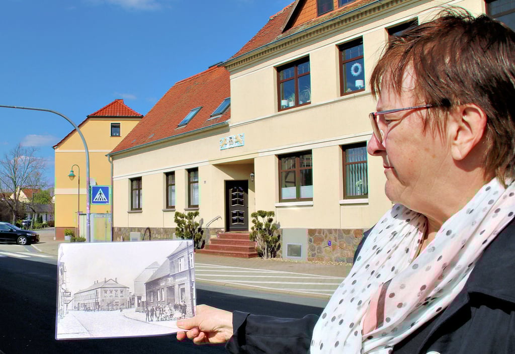 Heimatvereins-Vorsitzende Margitta Häusler mit einer alten Aufnahme vom Magdeburger Hof. In den letzten Kriegstagen ist die einst stolze Gaststätte in Brand geschossen worden.