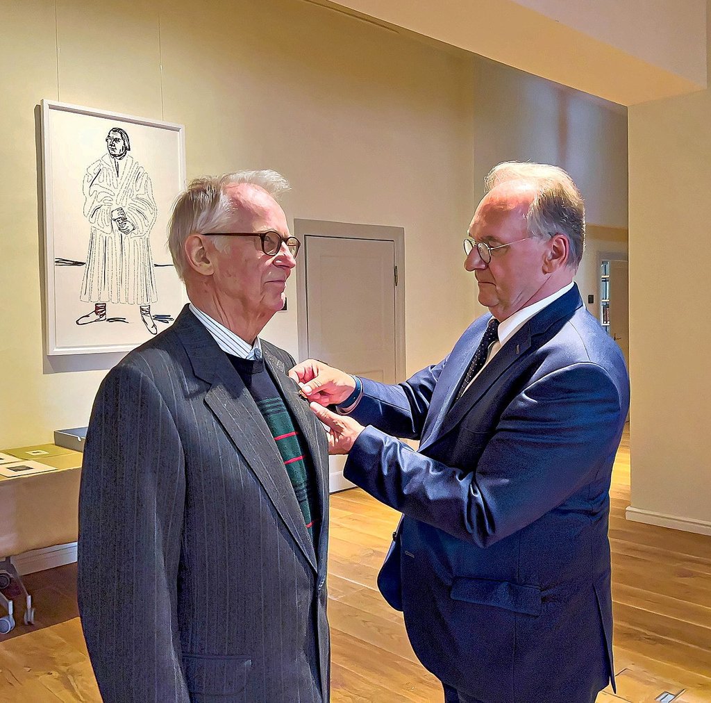 Ministerpräsident Haseloff (rechts) steckt Jürgen Krüger die Ehrennadel an.