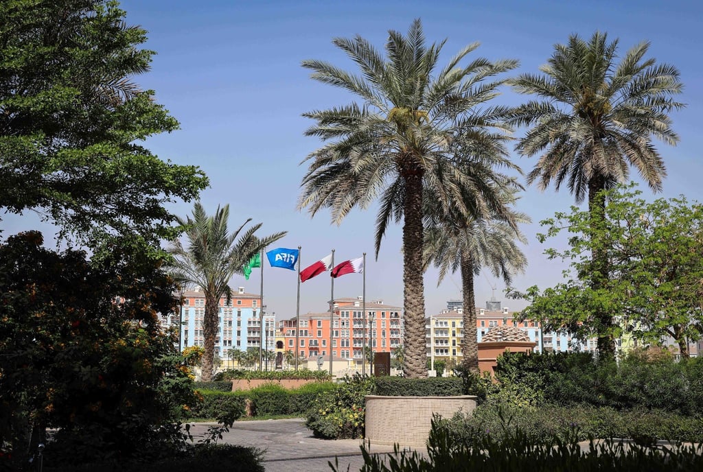 Die Flaggen Katars und der FIFA wehen vor einer Hotelanlage in Doha.