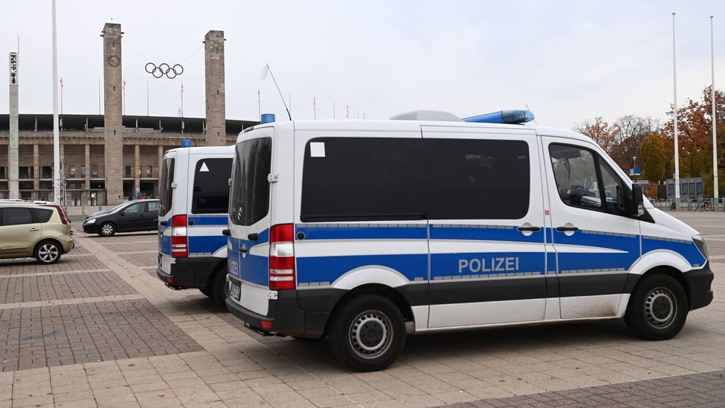 Polizeiautos stehen vor dem Berliner Olympiastadion, um ein Fußballspiel abzusichern.