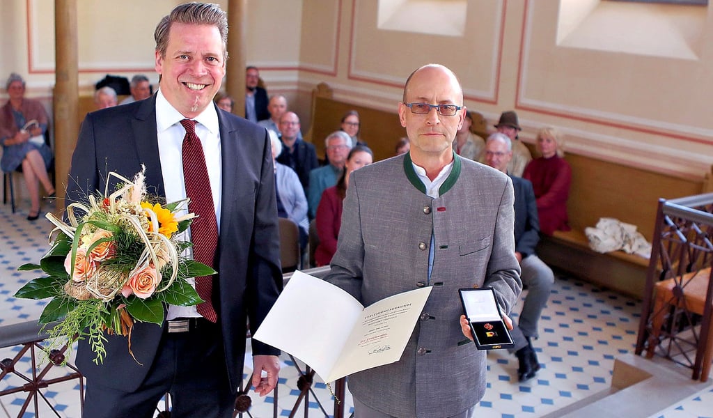 Staatssekretär Sebastian Putz zeichnet Dirk Honsa (r.) mit der Ehrennadel des Landes Sachsen-Anhalt aus.
