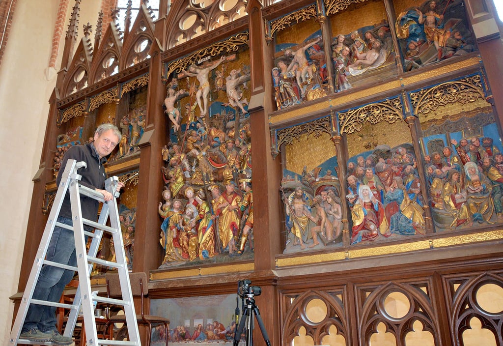 Der Berliner Diplom-Restaurator Dirk Jacob ist derzeit Herr über die rund 150 Bibelfiguren auf dem alten Schnitzaltar der Seehausen Petrikirche. Von oben nach unten verhilft er dem Kunstwerk mit Wattestäben, Spachtel und Pinsel zu altem Glanz