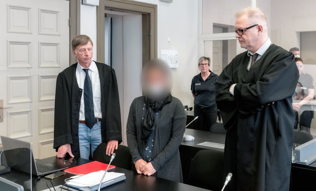 Die Angeklagte IS-Rückkehrerin aus Bremen steht zwischen ihren Verteidigern Jacob Hösl (r) und Johannes Pausch in einem Saal des Oberlandesgericht.