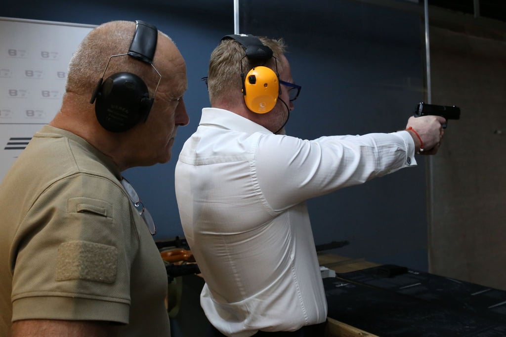 Unter den wachsamen Augen von Schießtrainer Krzysztof Przepiorka übt Unternehmensberater Piotr Piela mit der Pistole auf einem Schießstand.