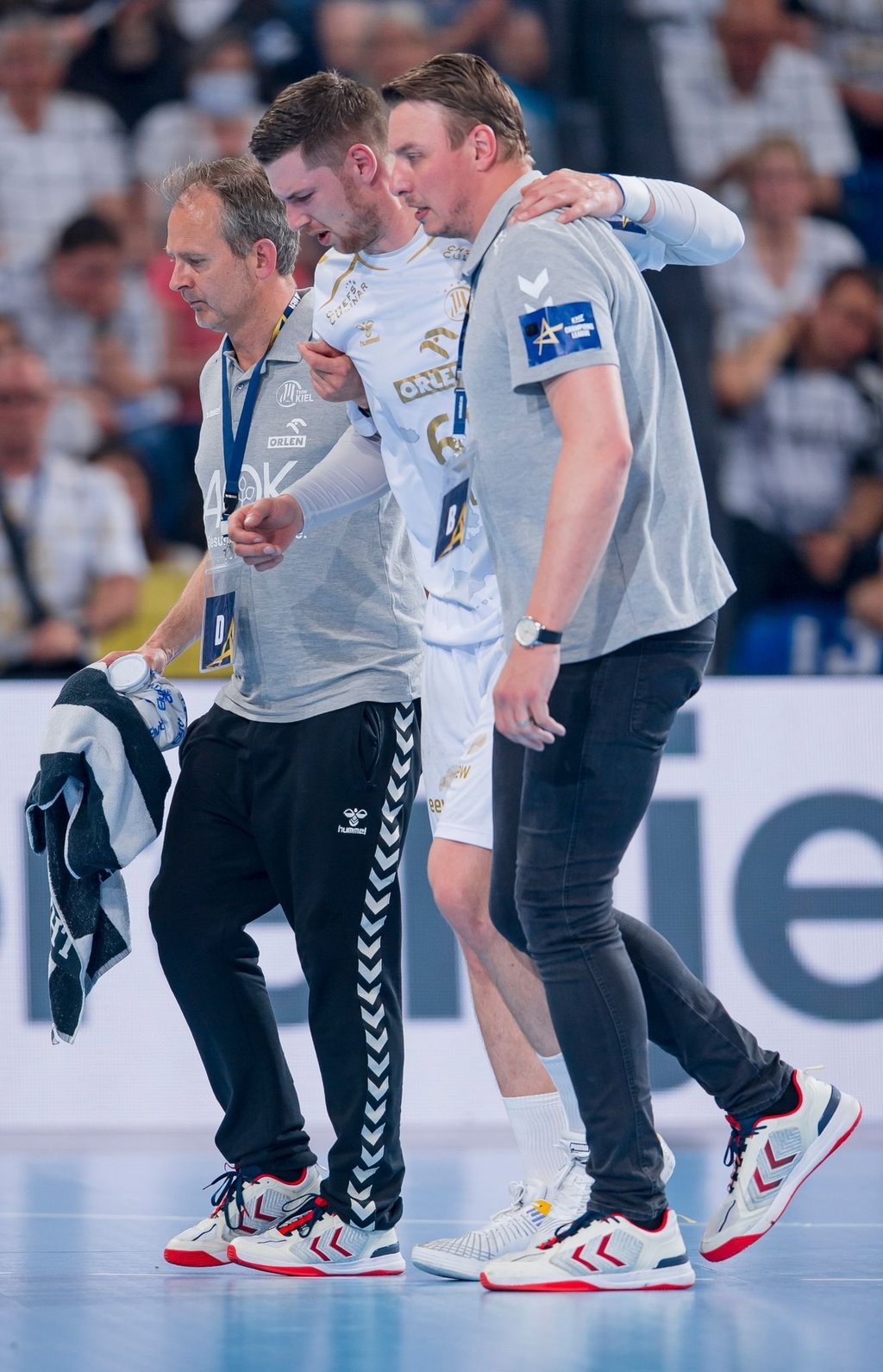 Kiels Hendrik Pekeler (M) wird verletzt vom Platz geführt.