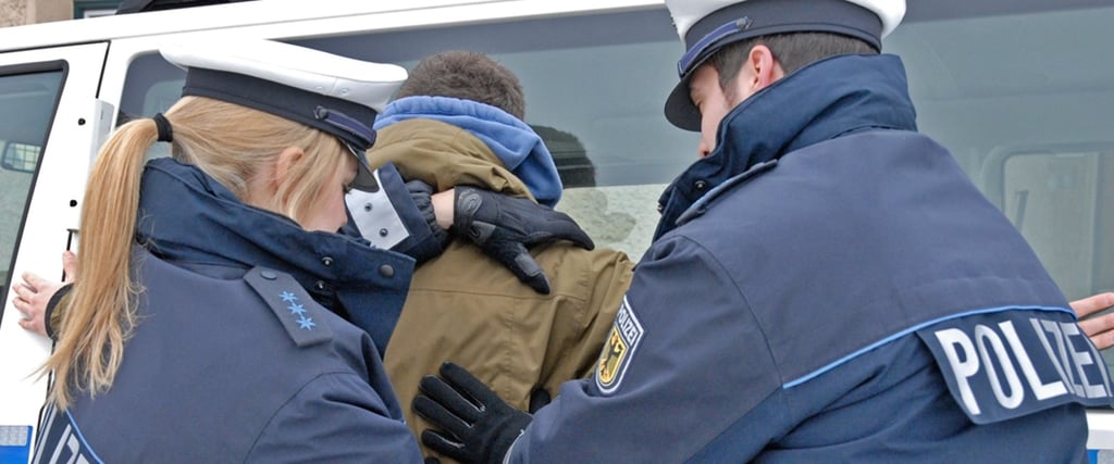 Die Polizei verhaftet einen Verdächtigen.