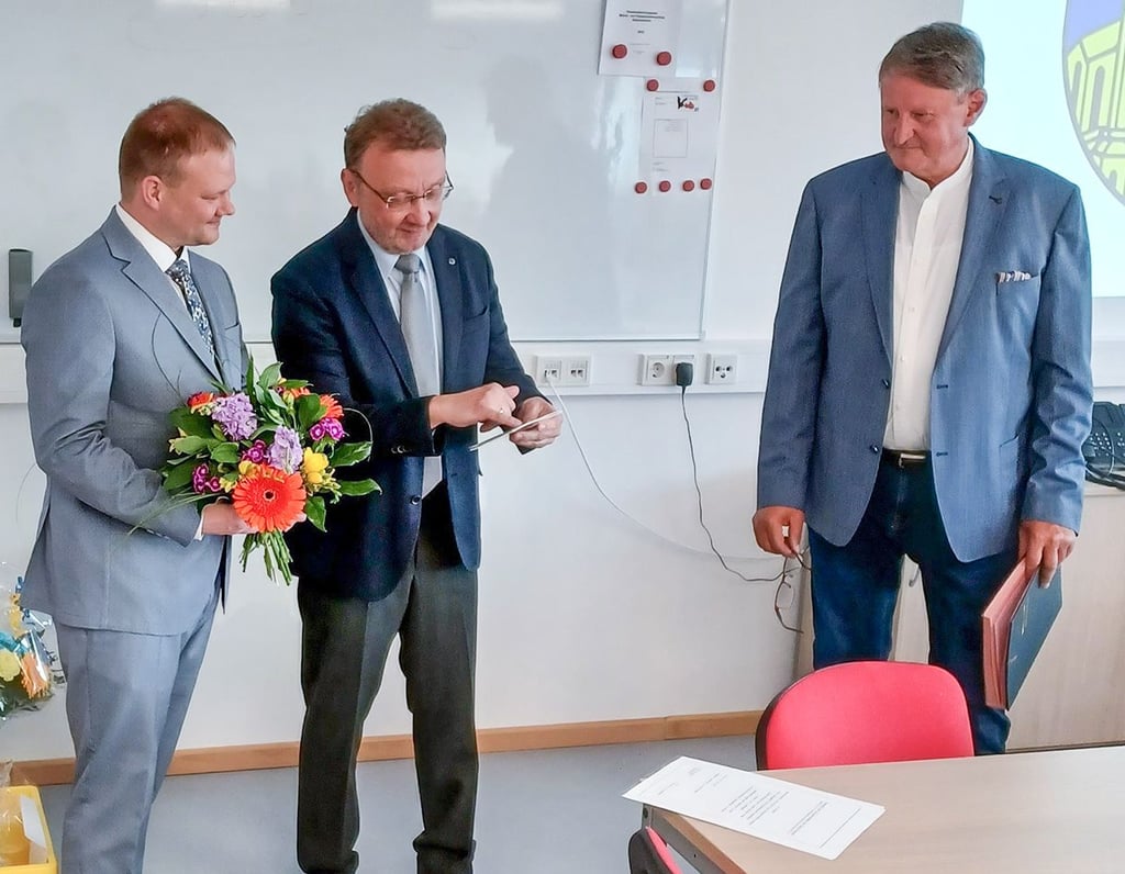 Martin  Zbyszewski (l.) überreicht seinem Vorgänger Mario Braumann im Beisein von Michael Claes (r.) zum Abschied  einen Blumenstrauß.  