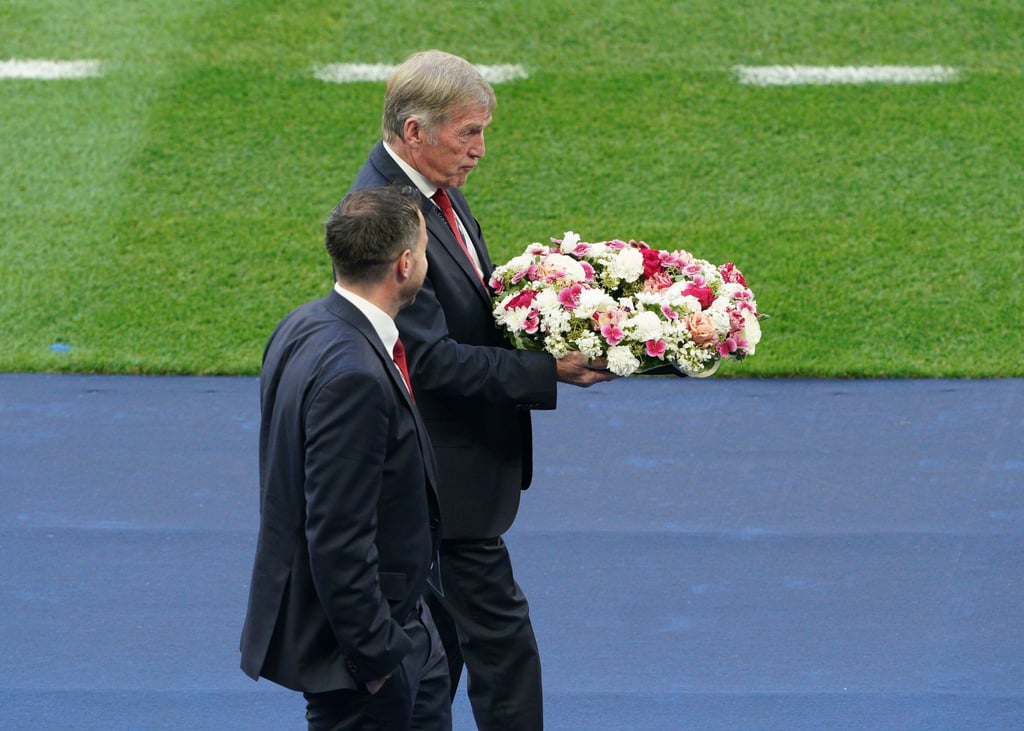 Liverpool-Legende Kenny Dalglish bringt den Kranz in Richtung eines hinter einem Tor angebrachten Vereinswappen der Reds.
