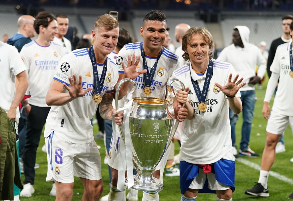 Toni Kroos (l), Carlos Casemiro (M) und Luka Modric von Real Madrid jubeln mit der Trophäe nach dem Sieg.