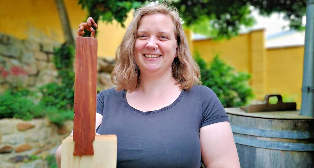 Seit fünf Jahren ist die Holzbildhauermeisterin Lea Diehl in Langenstein zu Hause. Die Akrobaten-Skulptur, die sie in die Kamera zeigt, stammt aus einer neuen Reihe. Diese präsentiert sie zu Pfingsten am Chiemsee in Bayern.