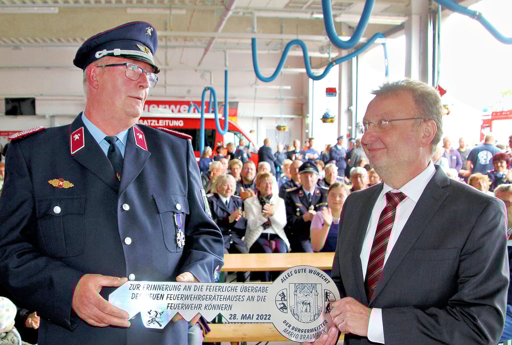 Könnerns Stadtwehrleiter Detlef Röthling (links) nahm unter dem Applaus der Zuschauer in der Fahrzeughalle den symbolischen Schlüssel für die neue Feuerwache vom scheidenden Bürgermeister Mario Braumann entgegen.