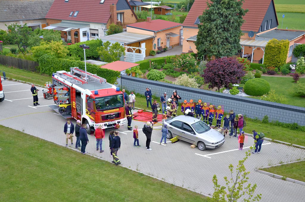 Blick von oben aus dem Drehleiterkorb des Löschfahrzeuges: Die Kameraden der Freiwilligen Feuerwehr Altenweddingen demonstrieren den Zuschauern, wie sie bei einem Unfall vorgehen.