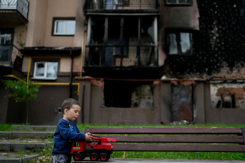 Vor einem zerstörten Gebäude in Irpin nahe Kiew spielt der kleine Yarik mit seinem Spielzeug-Lastwagen.