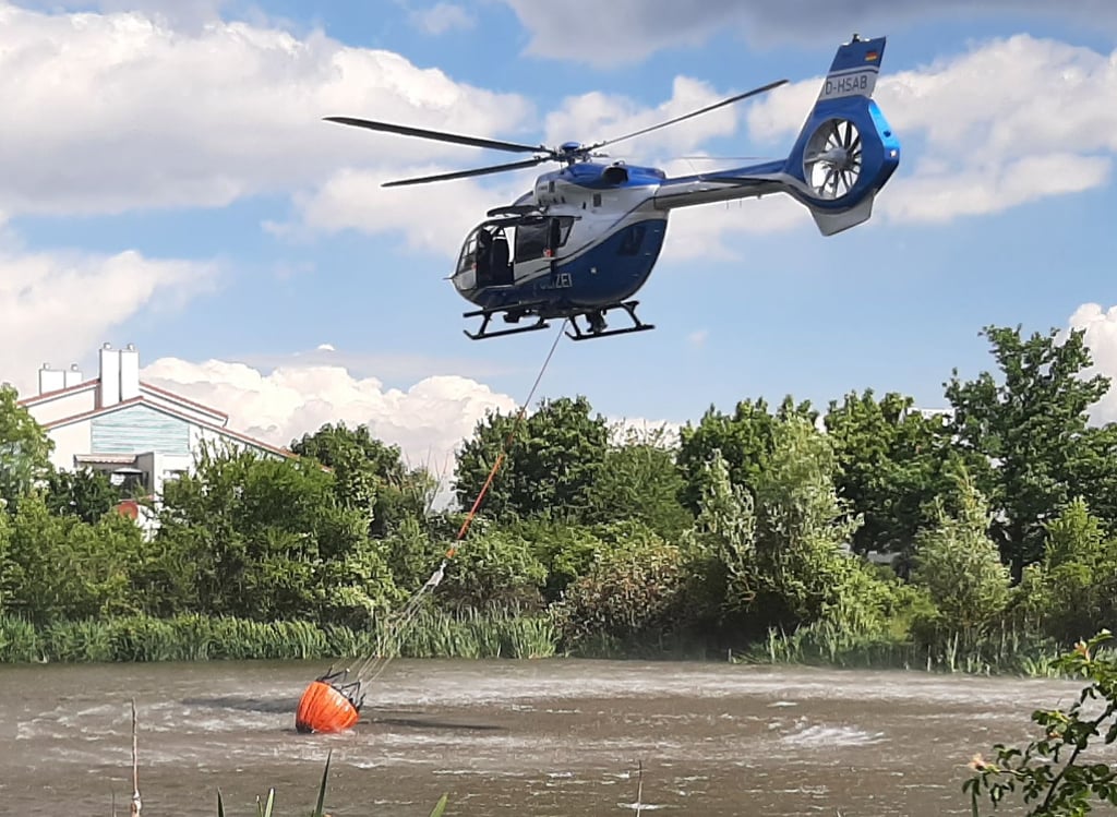 Der Löschhelikopter der Polizei bei der Löschwasser-Entnahme aus dem Teich in der Lerchenbreite.