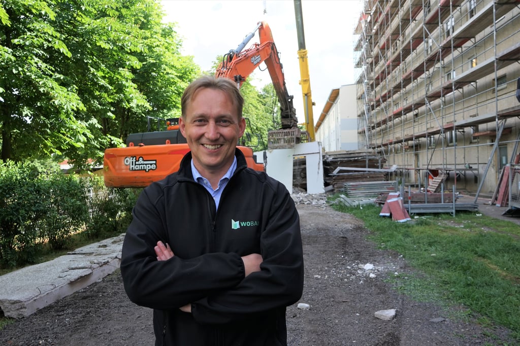 Salzwedels Wobau-Chef Christian Märtens ist glücklich: Wieder wird ein Betonriese saniert. Im Hintergrund ist der Höhenunterschied zu einem herabgesetzten Wohnblock zu sehen.