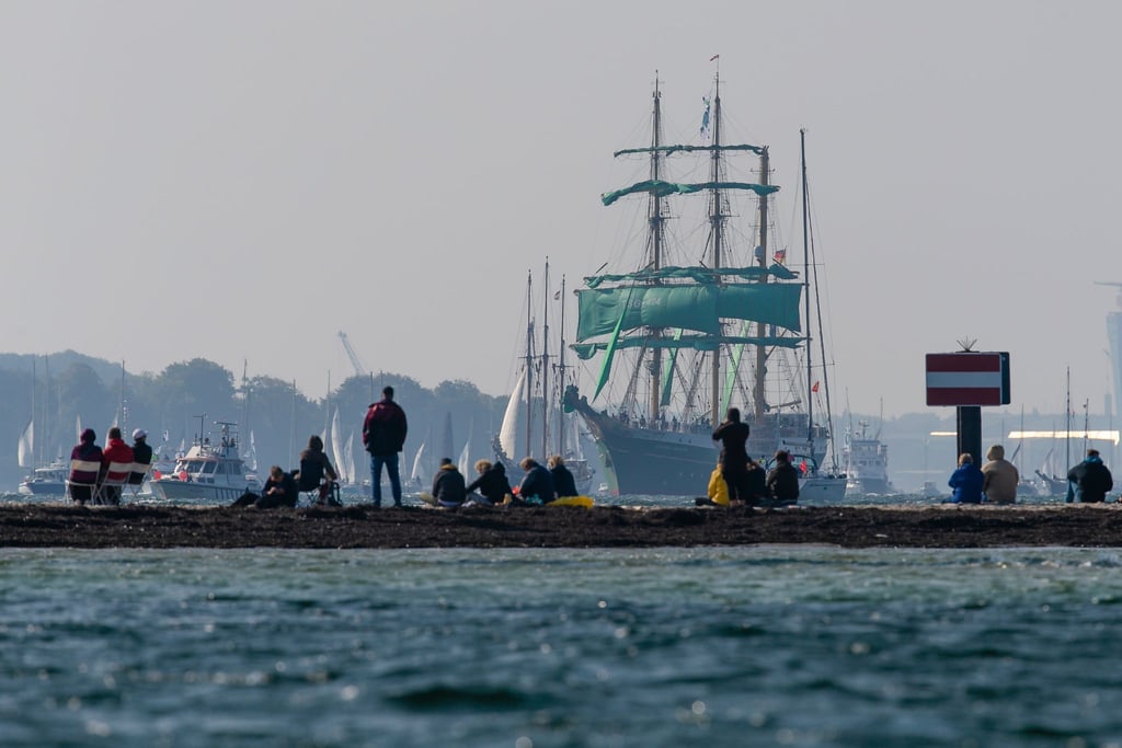 Zuschauer beobachten am Falkensteiner Strand die Windjammer-Parade der Kieler Woche. Die Stadt rechnet zum Sommerfest vom 18. bis 26. Juni mit einem Millionen-Publikum.