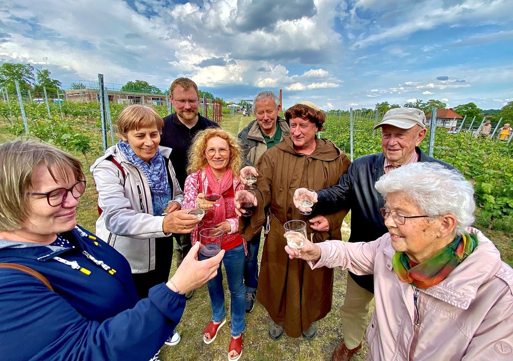 Mönch Roland Uebrig und die Besucher erfreuen sich an einem Schoppen Wein zur Begrüßung.