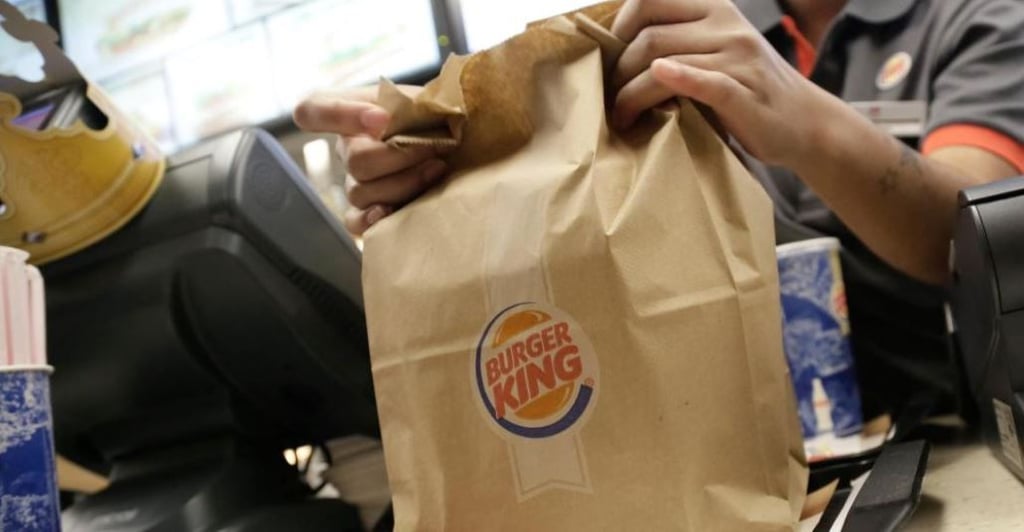Ein Mitarbeiter bei Burger King verpackt Speisen zum Mitnehmen