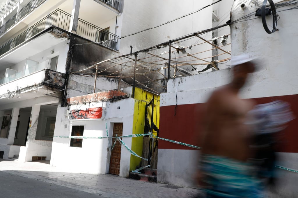 Menschen gehen nach dem Brand am Restaurant „Why Not Mallorca?“ vorbei.