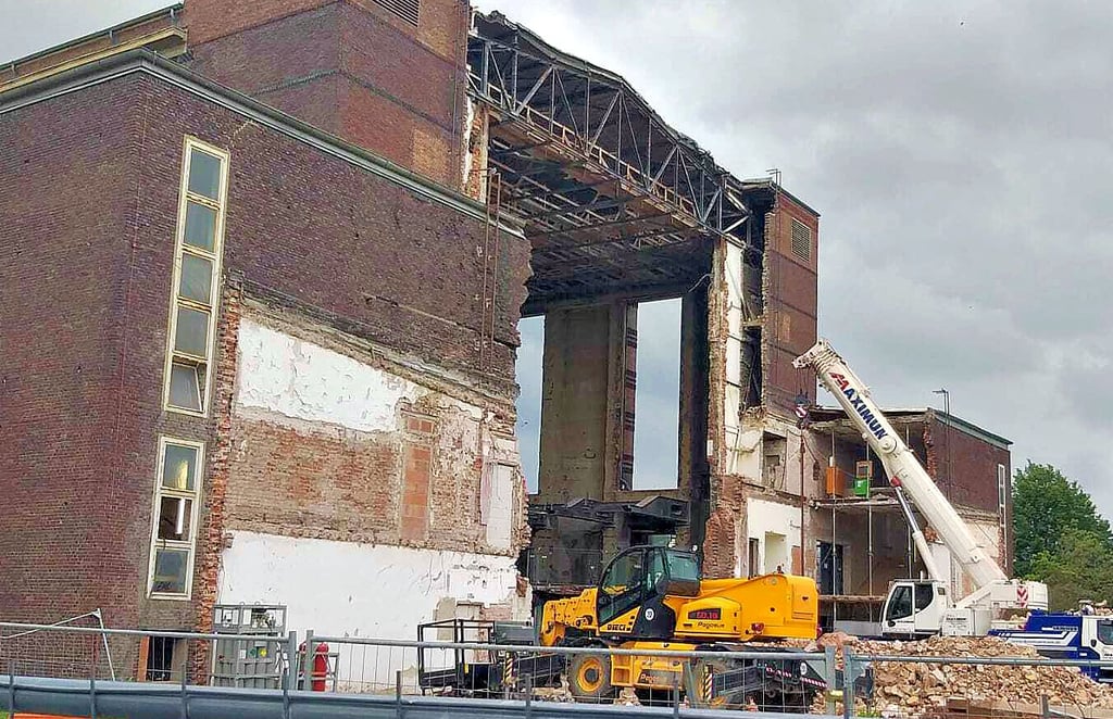 Bauarbeiten an der Stadthalle Magdeburg: Das Innere des Gebäudes ist weitgehend freigeräumt und in einer Außenwand klafft inzwischen ein großes Loch. Im Zuge der Erneuerung sollen auch die Außenanlagen neu gestaltet werden.
