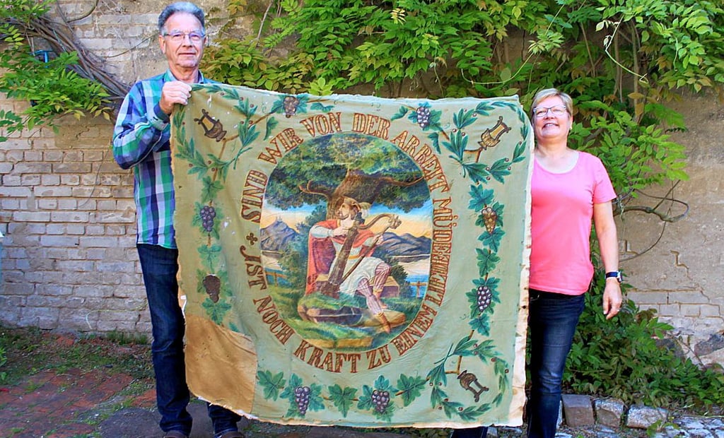 Karin und Jürgen Kanstorf präsentieren die historische Fahne aus den 1860er Jahren.