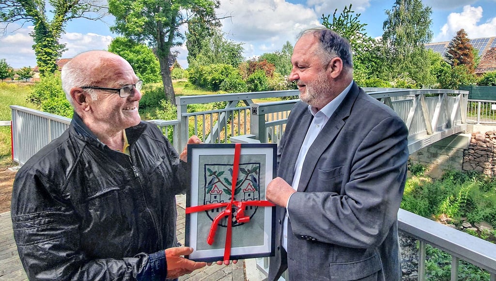 Albrecht Schneidewind bedankt sich bei Andreas Michelmann mit einem von seiner 96-jährigen Schwiegermutter einst gestickten Wappenbild.