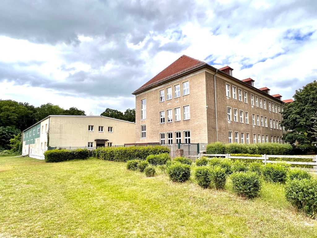 Links die Sporthalle, rechts das Schulhaus der Bietheschule Roßlau. Die Schule soll 2023 vom Stadtrand in das Roßlauer Zentrum umziehen. Vereine machen sich Sorgen um die Zukunft der Turnhalle nach dem Leerzug des Schulhauses. Foto: T. Ruttk