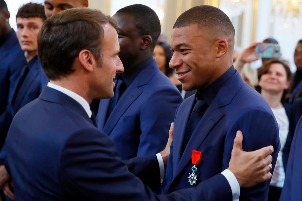 Frankreichs Präsident Emmanuel Macron (l) spricht bei einer Ehrung der Weltmeister von 2018 mit Kylian Mbappe.