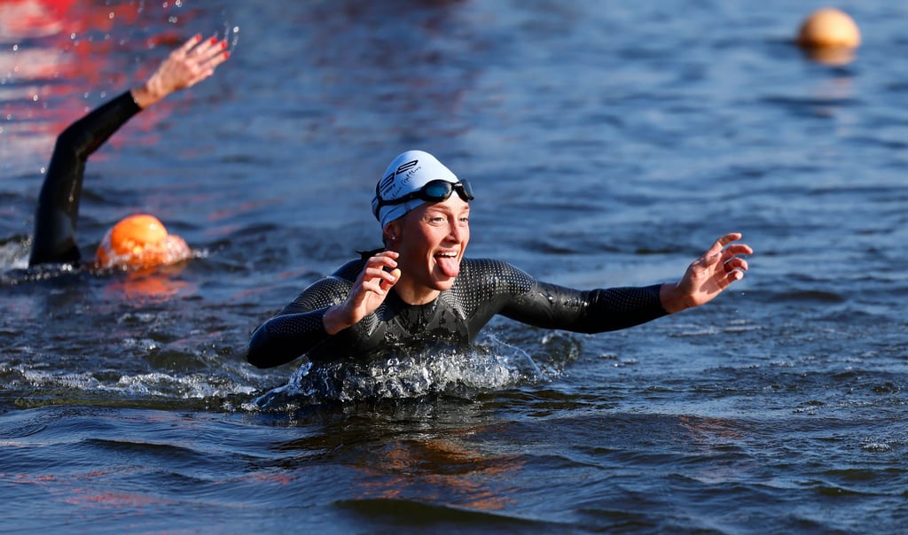 Die britische Sportlerin Katrina Matthews (r) verlässt nach dem Schwimmen den Senftenberger See.