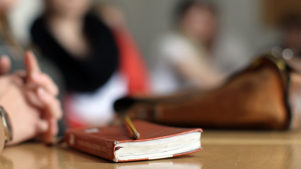 Ein Buch und eine Tasche liegen auf einem Tisch. In Sachsen-Anhalt geht die Zahl der Schüler in Abendschulen zurück. Jetzt wird über eine Fusion der Schulen in Halle und Magdeburg nachgedacht.