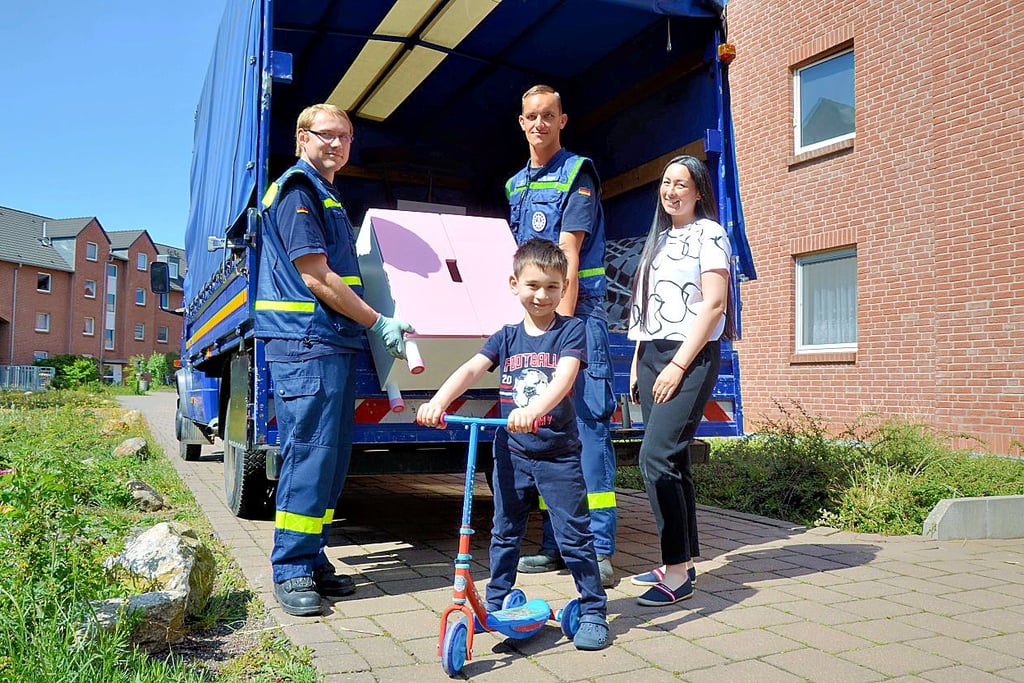 Zwei Helfer vom THW bringen Nataliya Tkachenko und ihrem Sohn Samvel Möbel für das Kinderzimmer und Fahrräder.