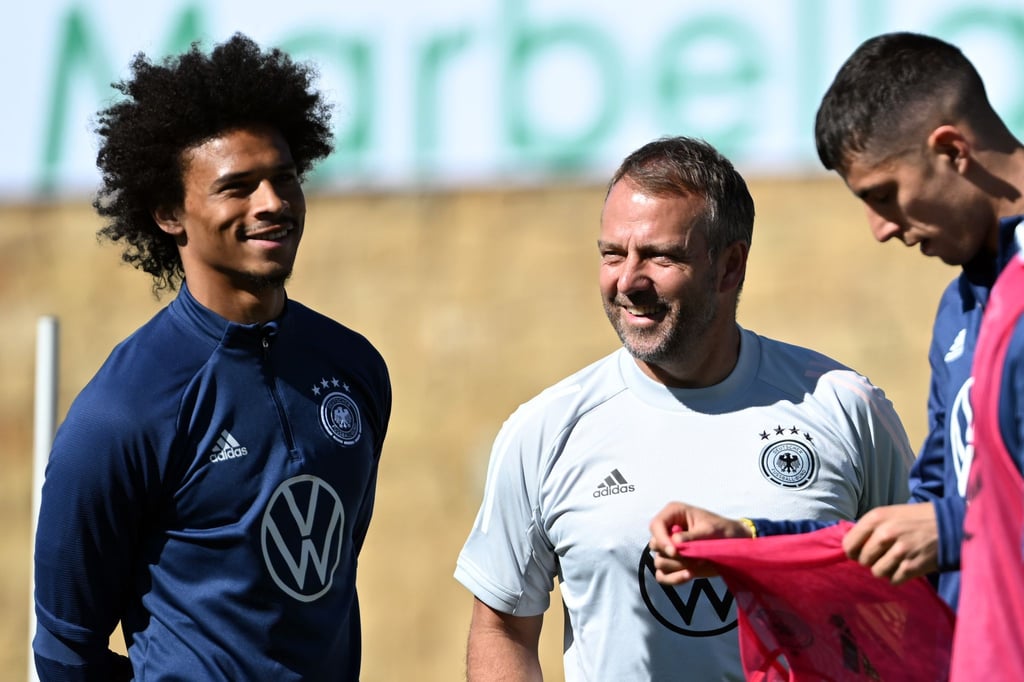 Bundestrainer Hansi Flick (r) spricht mit Leroy Sané während des Trainings.