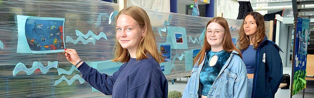 Isabel Rietz, Celine Sell und Annabelle Tiedge (von links) präsentieren die Meeresausstellung im Jahn-Gymnasium.