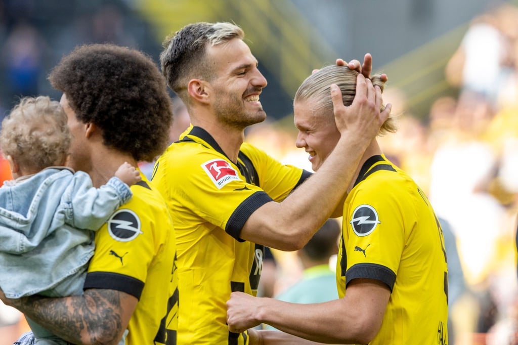 Vom VfL Wolfsburg an den BVB ausgeliehen: Marin Pongracic (M) umarmt Erling Haaland (r).