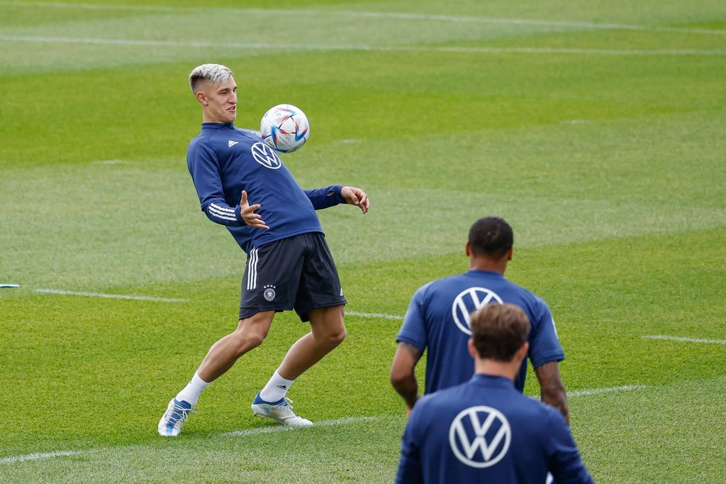 BVB-Neuzugang Nico Schlotterbeck (l) spielt beim Training der deutschen Nationalmannschaft beim Aufwärmen mit dem Ball.