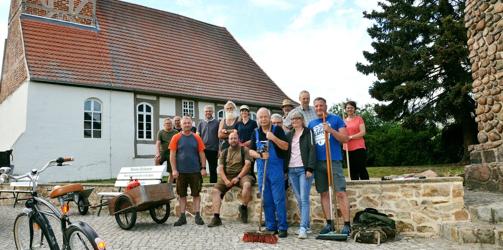 Um den Ortsbürgermeister Rüdiger Kunze (vorne links) haben sich die Ranieser zum dritten und letzten Arbeitseinsatz vor der Begehung am 14. Juni versammelt, um die finalen Arbeiten durchzuführen. Am Mittwoch Abend waren knapp 20 Bewohner tatkräftig im Einsatz und brachten dafür auch allerlei Gerätschaften mit.