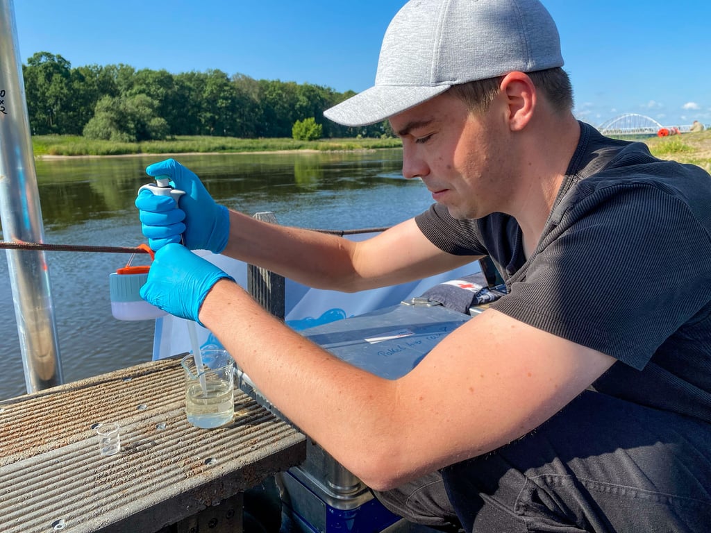 René Zippel nimmt eine Wasserprobe aus der Elbe, die er auf Schadstoffe prüft.