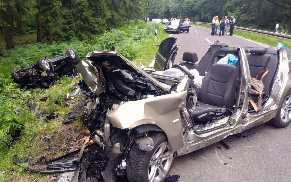 Zwei vollkommen zerstörte Autos liegen nach dem Unfall am Rand der Landstraße L12 zwischen Roetgen und Simmerath in der Eifel. (Archivbild)
