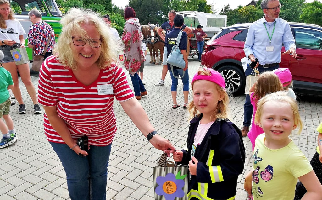Die Kinder aus Spora bereiten der Jury einen herzlichen Empfang. Nach einem Rundgang und einem Lied gab es Geschenke. Leni Gerste (rechts) und die kleine Feuerwehrfrau Lotta Beyer übergeben Andrea Eimkemeier-Bertram eine selbst gebastelte Erinnerung.