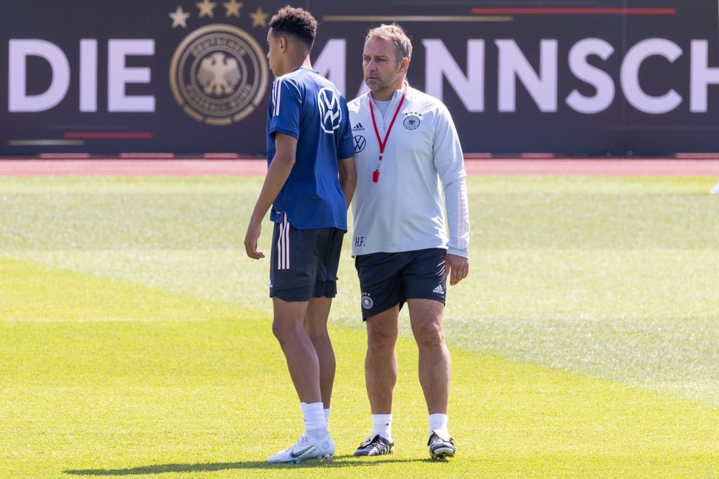 Bundestrainer Hansi Flick (r) spricht während des Trainings der deutschen Nationalmannschaft mit Jamal Musiala.