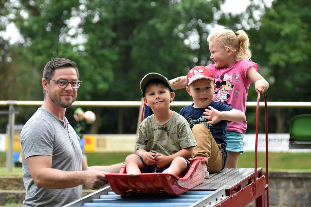 Lasse (v. vorn), Arne und Zoe testen die Sommerrodelbahn. Daniel May ist einer der Väter der Sportkidner und beaufsichtigt die Bahn.
