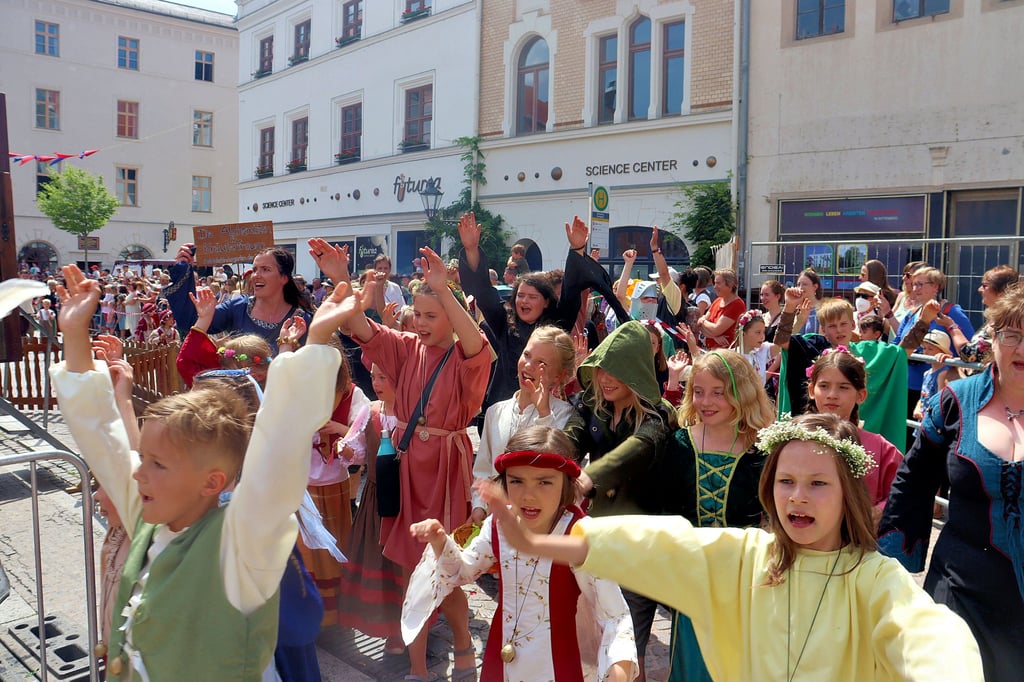Jungen und Mädchen aus Grundschulen, Kitas und Vereinen präsentieren während ihres Umzugs insgesamt 22 historische Bilder.