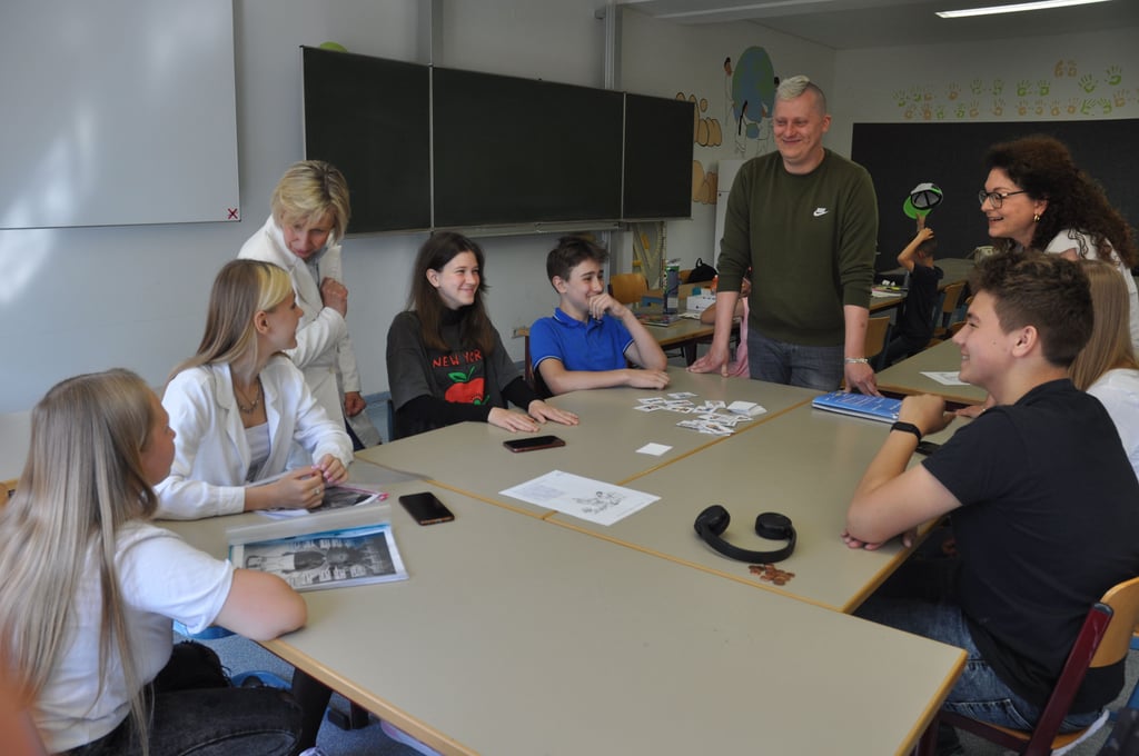 Cornelia Blödow, die leiterin der Kreisvolkshochschule (stehend links), nutzte den Besuch der Ankunftsklasse, um mit den ukrainischen Jugendlichen zu sprechen. Sie werden von Adrian Zawadzki und Anna Wolfowski (rechts) unterrichtet.