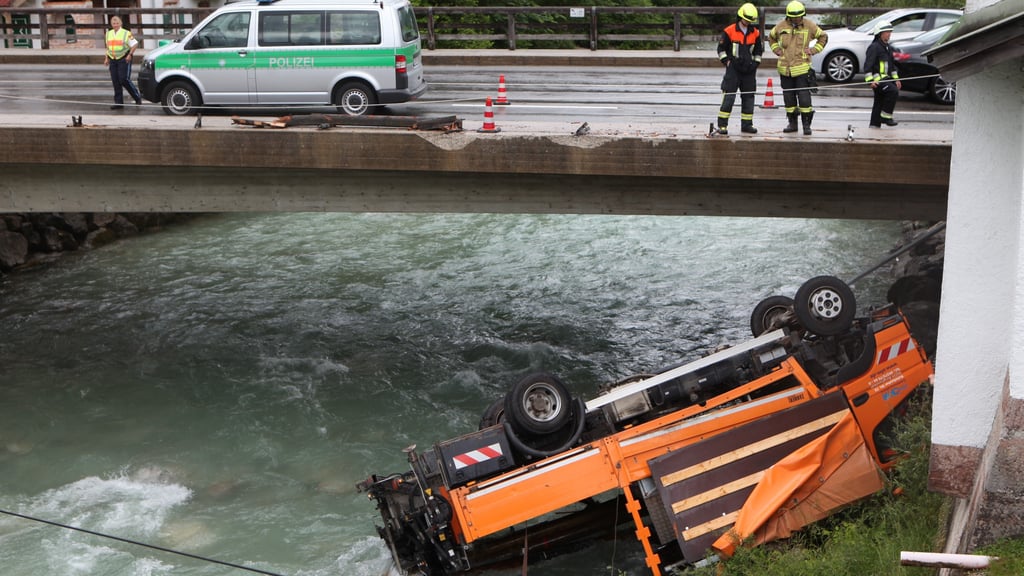 Ein Lastwagen liegt nach einem Unfall im Flussbett der Berchtesgadener Ache. Der Lkw war zuvor aus zunächst ungeklärten Gründen durch das Geländer der Schießstättbrücke gebrochen.