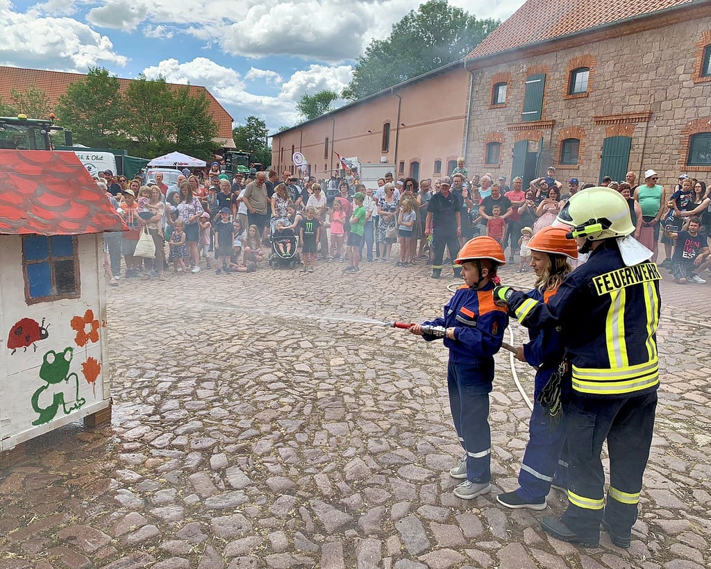Mädchen und Jungen der Kinderfeuerwehr Görzig demonstrieren ihr Können bei einem Löschangriff.