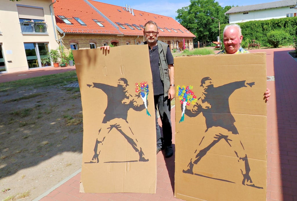 Werner Srugies und Jens Schmidt (rechts) treffen Vorbereitungen für das Theaterstück der „AugustinusDiestler" am Sonnabend während des Sommerfestes auf dem Diest-Hof Seyda. Dabei wird dem Blumenwerfer von Streetart-Künstler Banksy eine besondere Rolle zukommen.