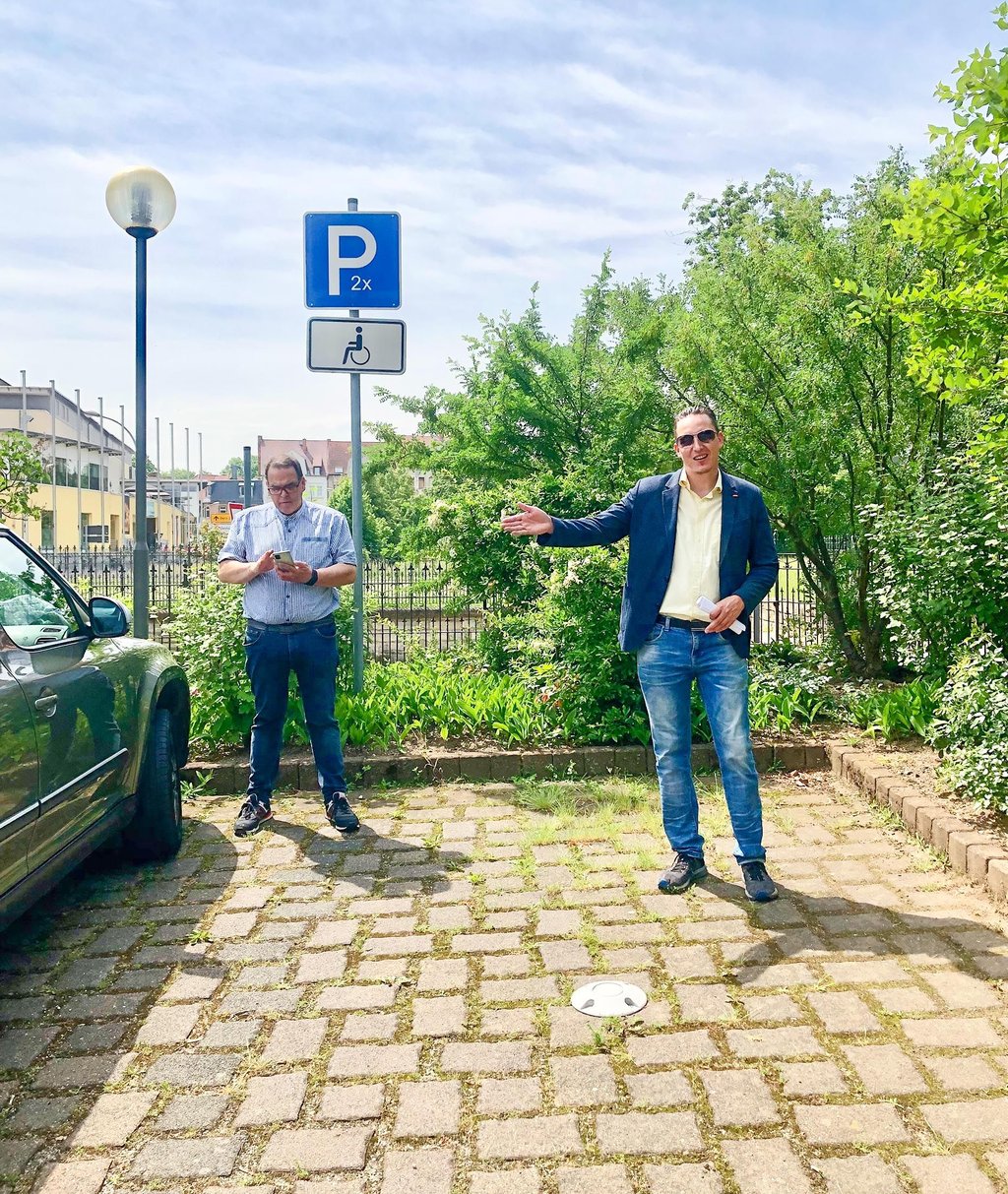 Matthias Laue, Projektmitarbeiter im Digitalisierungszentrum Zeitz, erklärt auf dem Parkplatz an der Moritzburg Zeitz, wie der Sensor funktioniert.