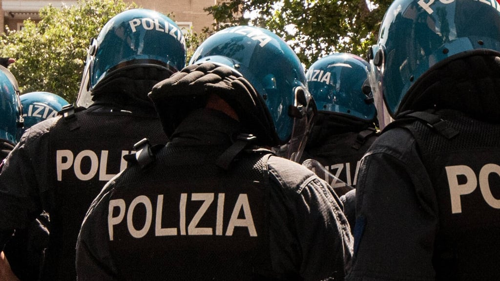 Mit Helm und Schutzausrüstung warten italienische Sicherheitskräfte auf ihren einsatz.