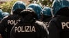 Mit Helm und Schutzausrüstung warten italienische Sicherheitskräfte auf ihren einsatz.