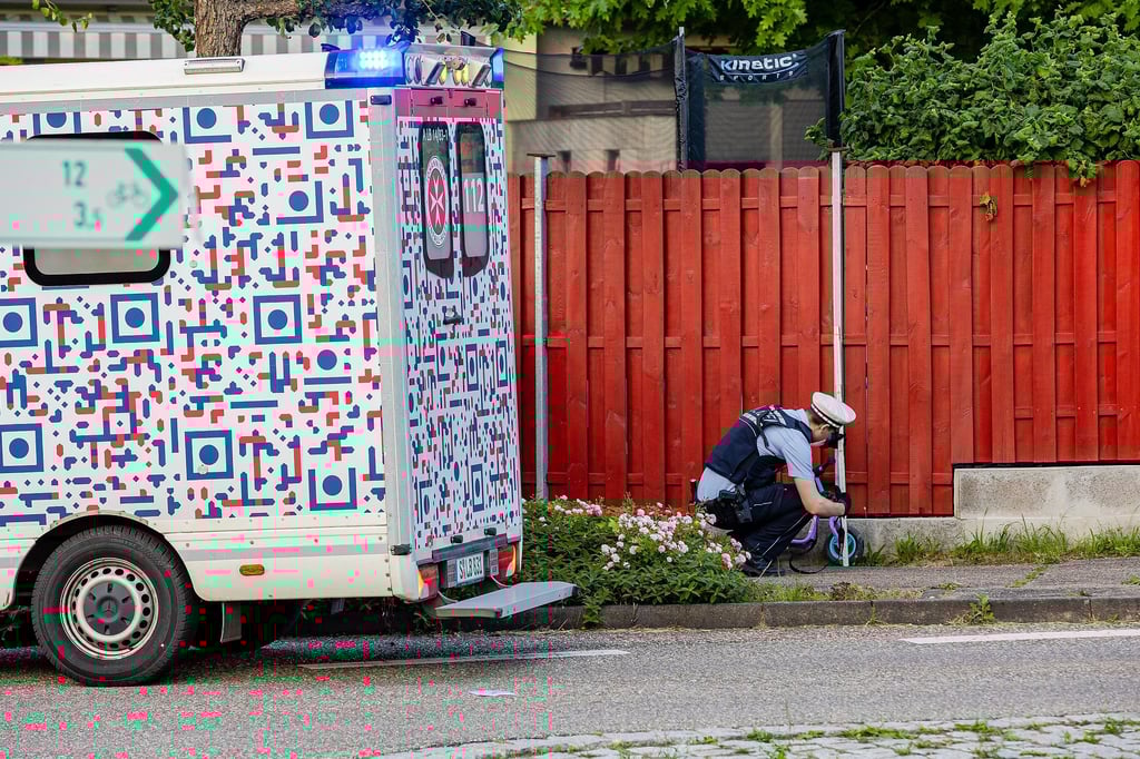 Ein Polizist untersucht das Laufrad eines Kindes an der Unfallstelle. Ein zweijähriges Mädchen und seine Mutter sind bei Murr von einem Auto angefahren und schwer verletzt worden. Die Fahrerin flüchtete.